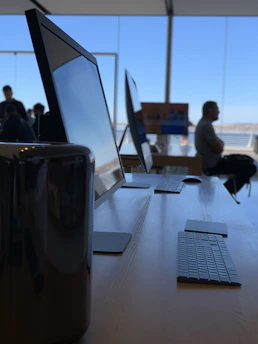 A sleek modern workspace with multiple screens showing software development and IT support dashboards.