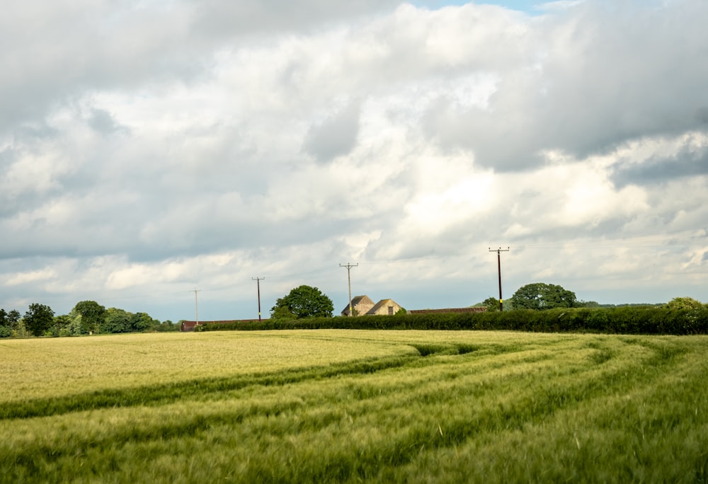 brown house on green grass field under white clouds during daytime