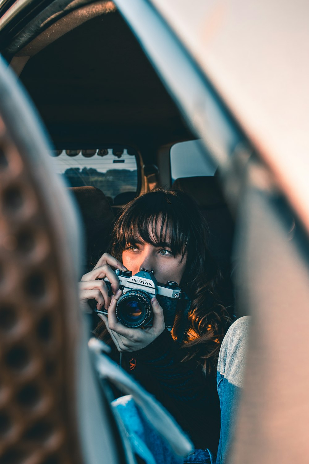 woman in white and black floral shirt holding black dslr camera