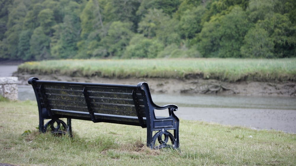 black wooden bench on green grass field during daytime