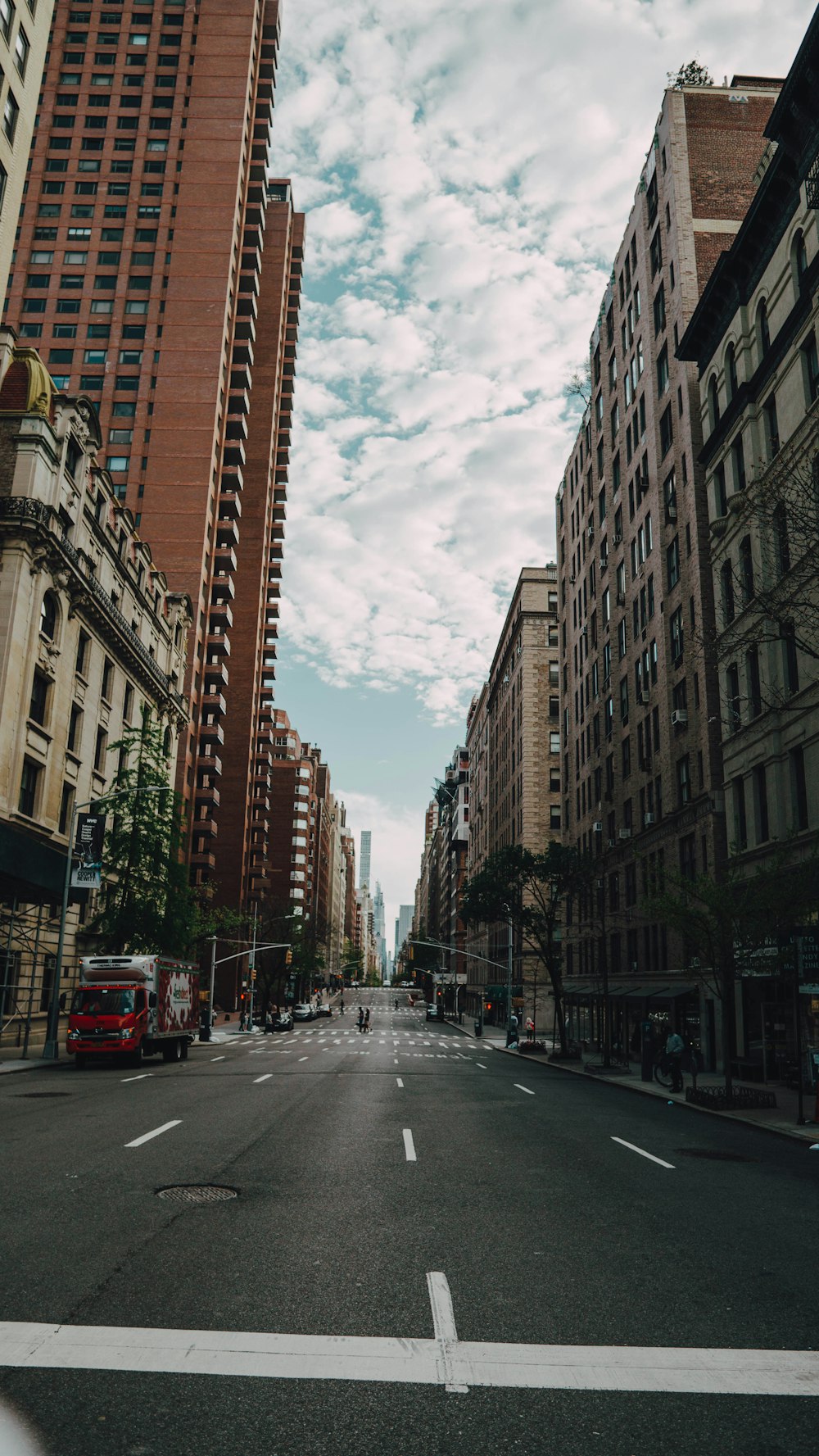 cars on road between high rise buildings during daytime