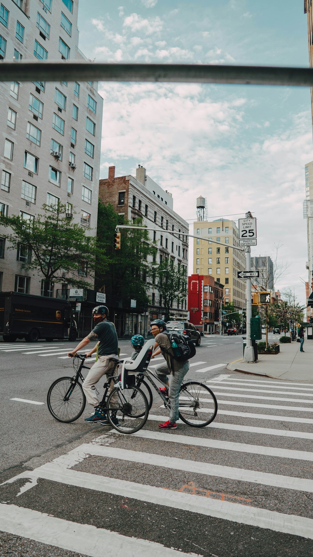 man in black jacket riding on bicycle on road during daytime