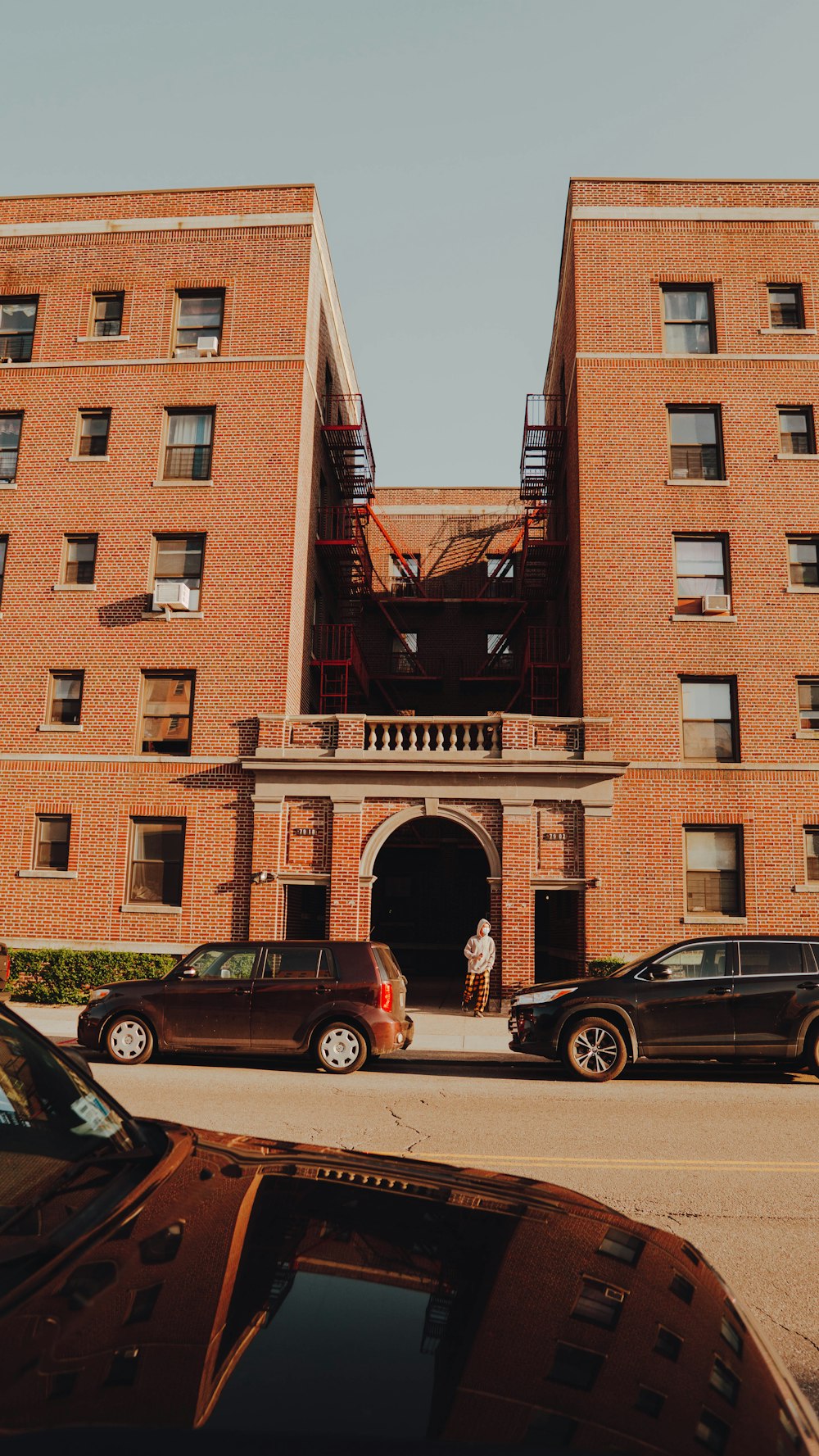 two cars parked in front of brown building