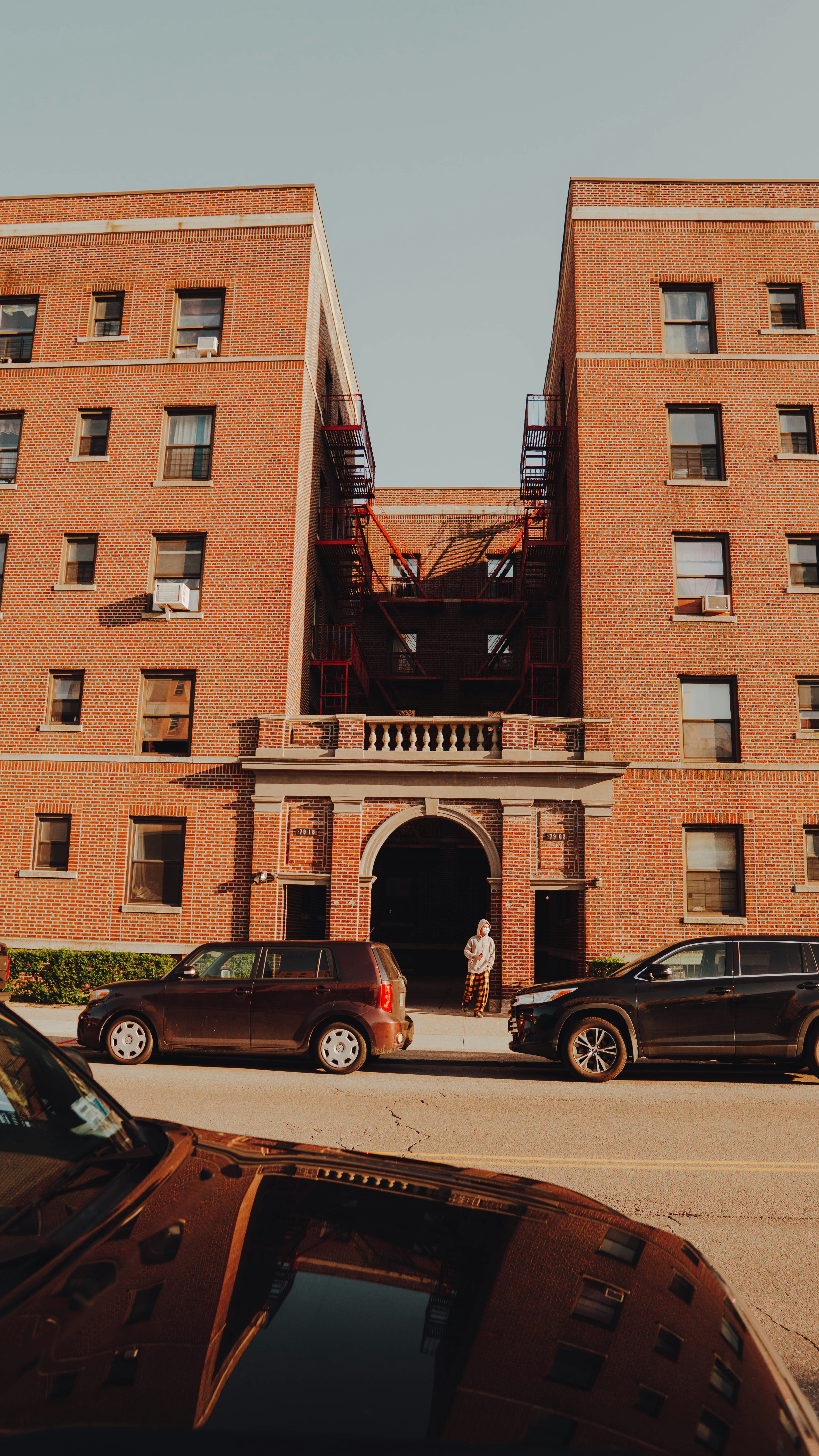 two cars parked in front of brown building