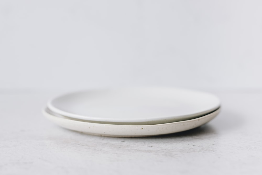 白いテーブルの上に白い丸い皿