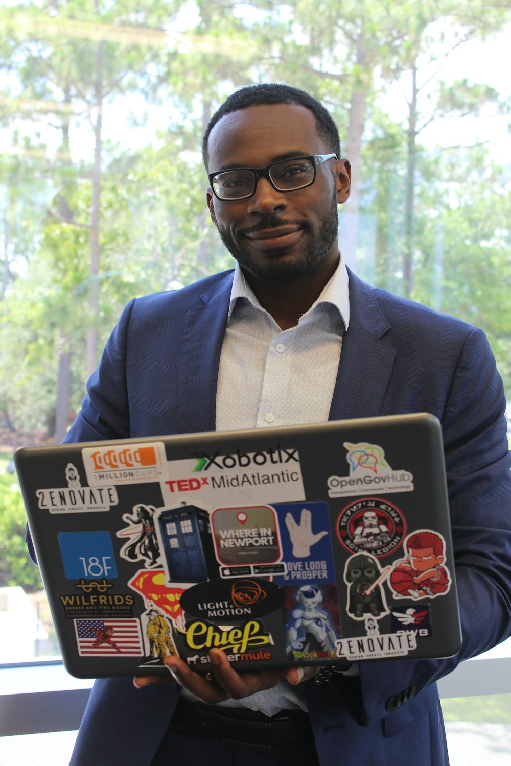 man in blue suit jacket holding book