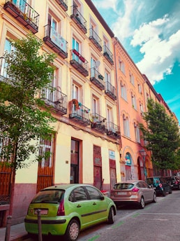 A vibrant street scene in Havana with classic cars and colorful buildings under a bright blue sky.