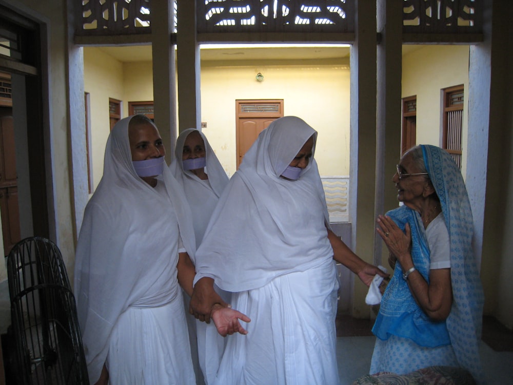 woman in white hijab standing beside man in blue dress shirt