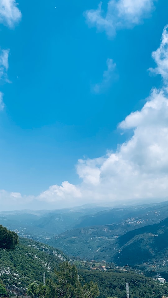 white clouds over green mountains during daytime in Baskinta Lebanon