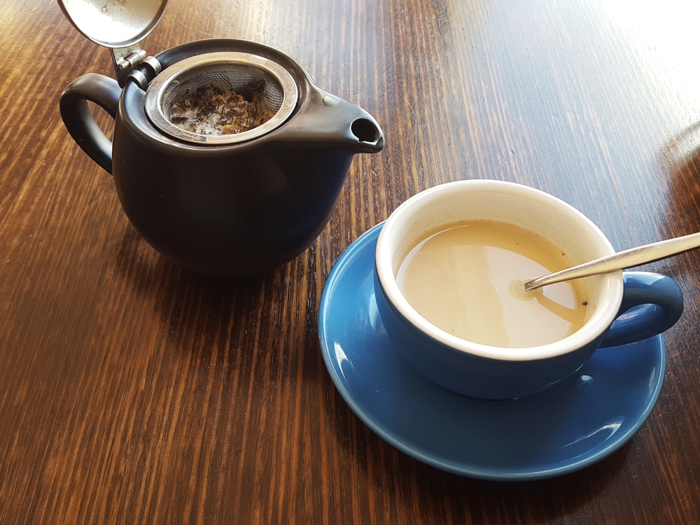 white ceramic teacup on blue ceramic saucer