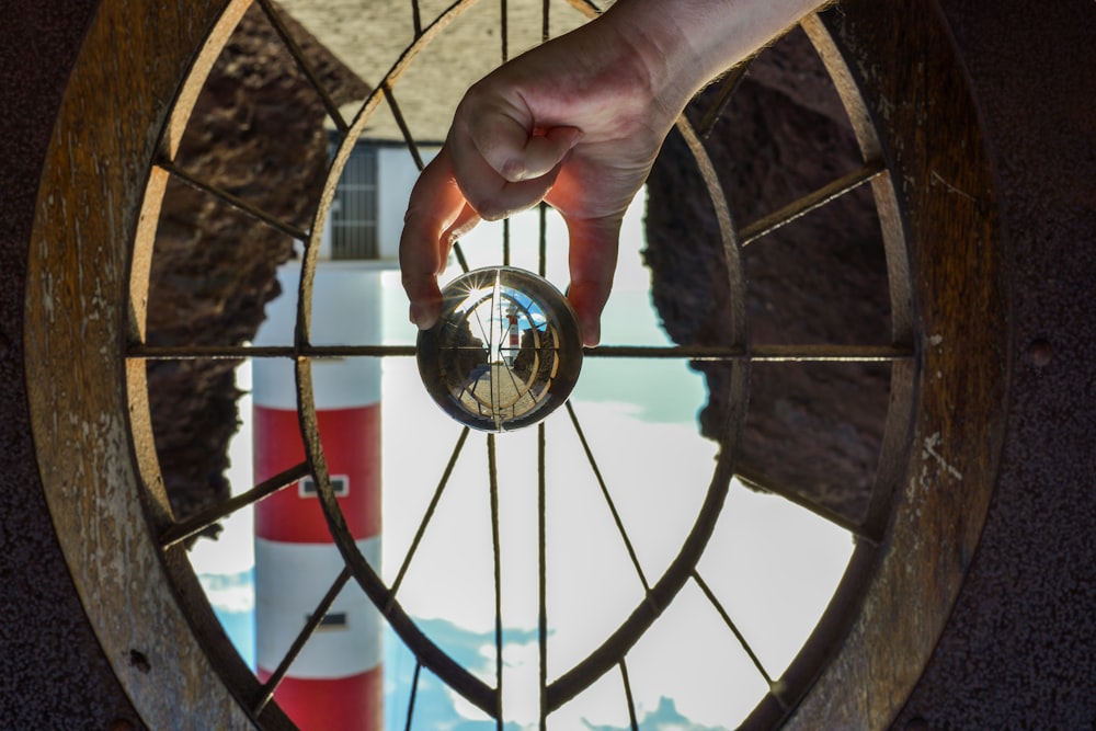 person holding round glass mirror