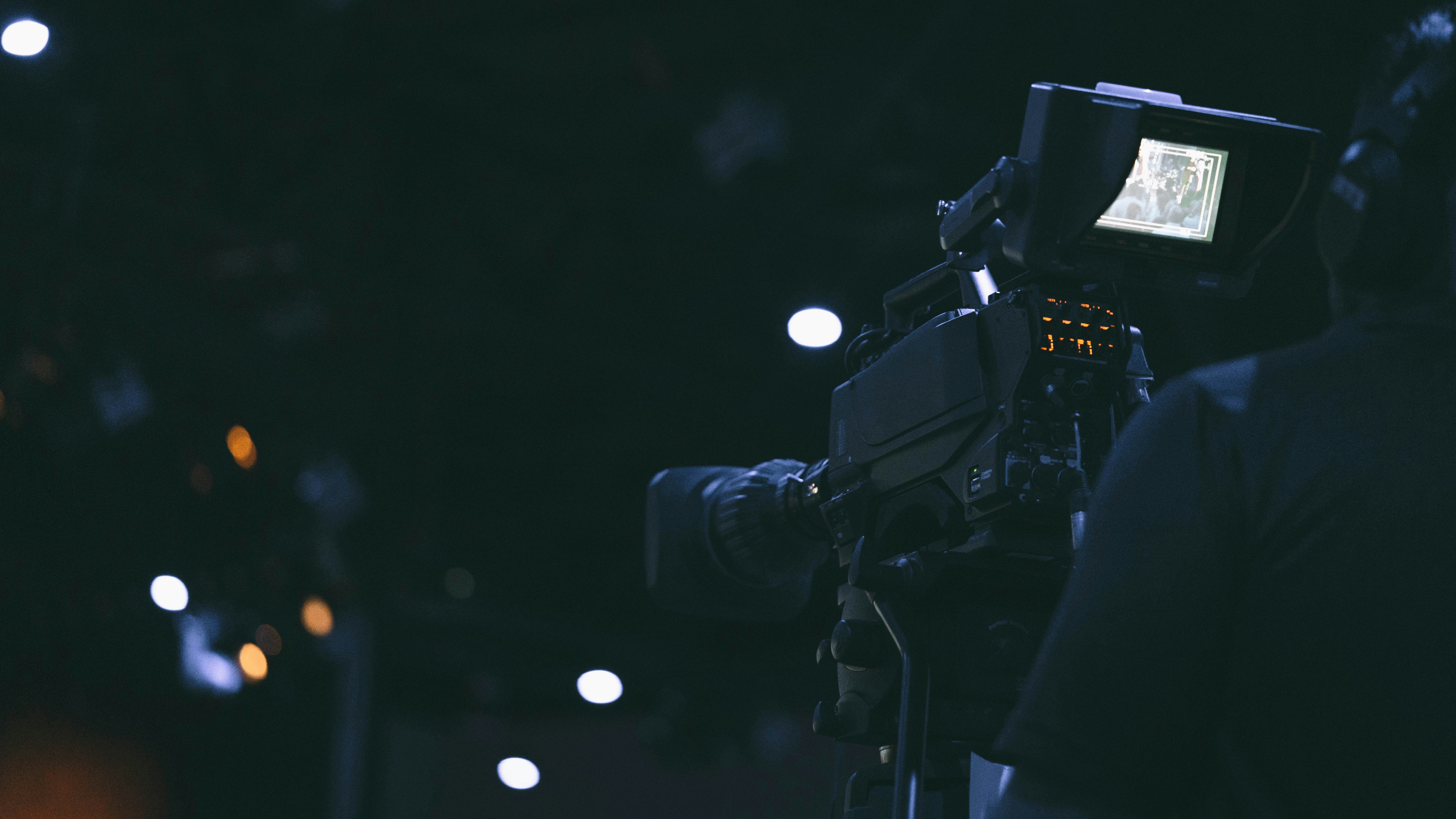 black video camera on black tripod