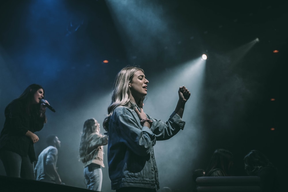 woman in black leather jacket standing on stage