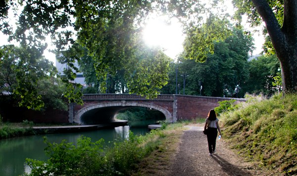 A walker on the towpath of the canal — Toulouse, France