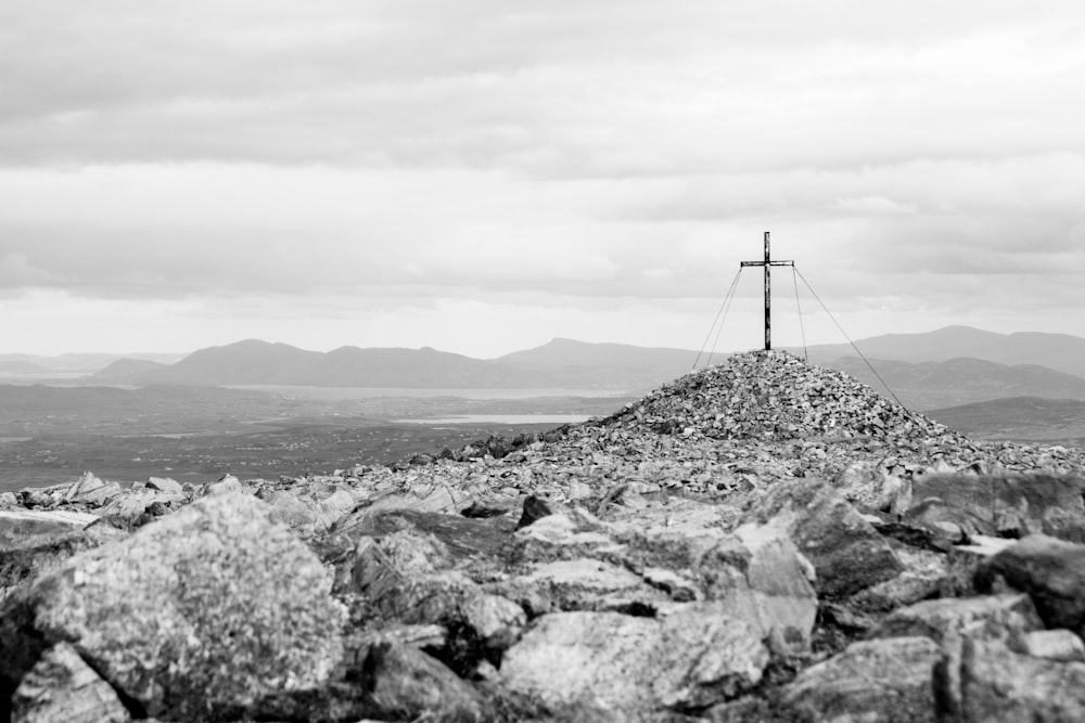 grayscale photo of a windmill on a hill