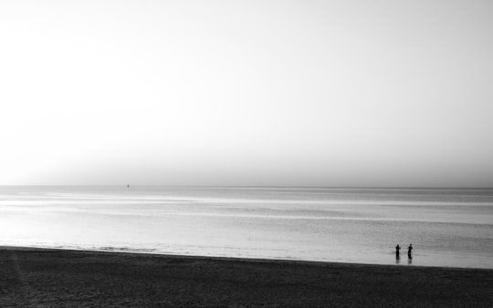 grayscale photo of person walking on beach in Île de Ré France