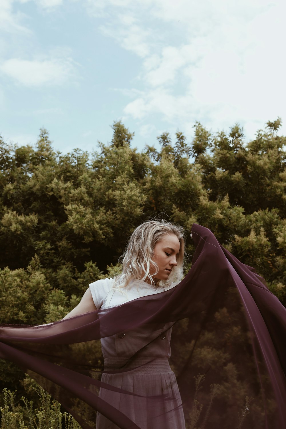 woman in purple dress sitting on purple hammock during daytime