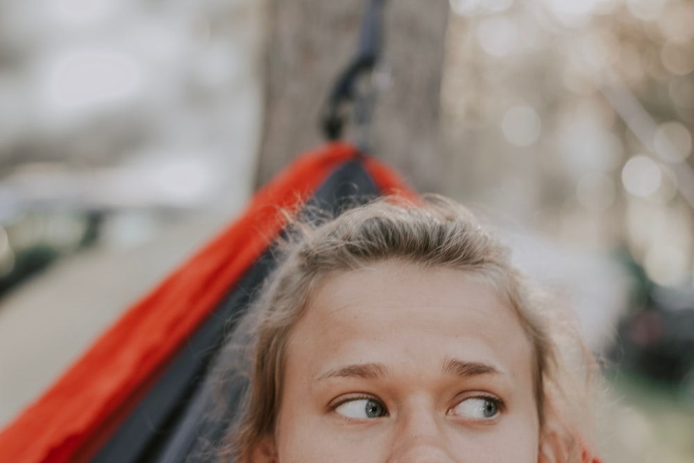 girl lying on red and black hammock