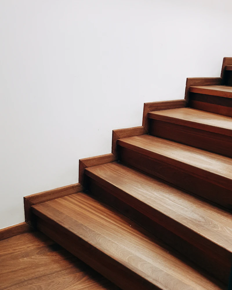 Treppenstufen aus Holz vor einer hellen Wand