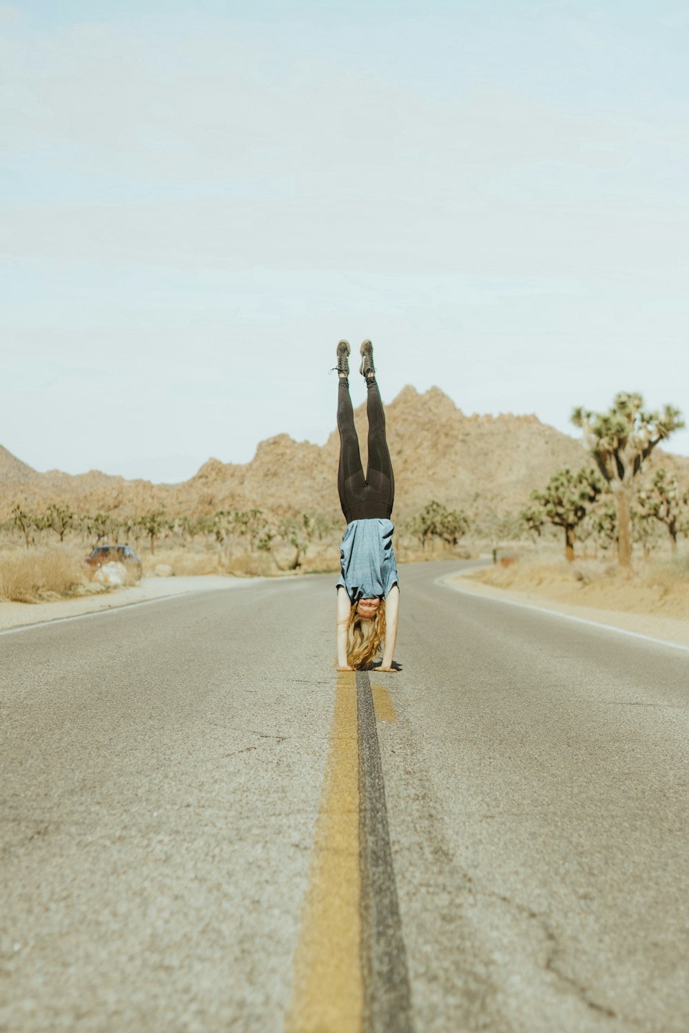 woman in black tank top and blue denim shorts standing on road during daytime