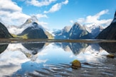 body of water near mountain under blue sky during daytime