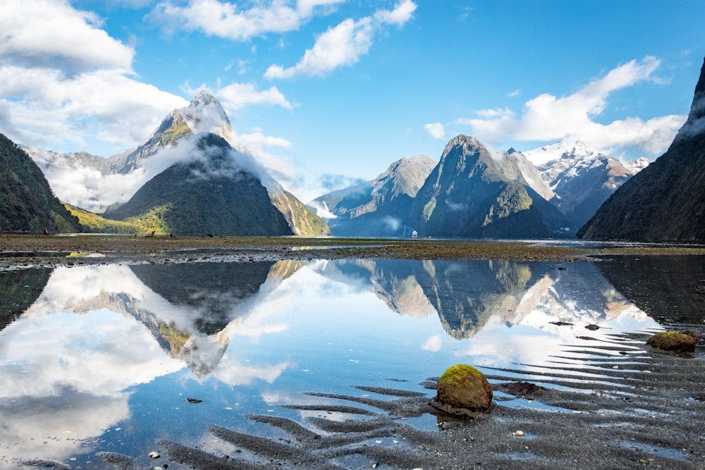 body of water near mountain under blue sky during daytime