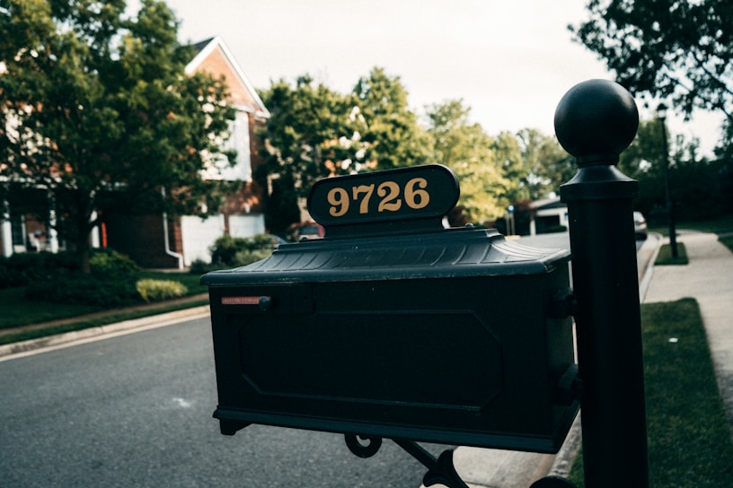 Close-up of a freshly repaired mailbox post with new metal numbering in a suburban Ohio driveway.