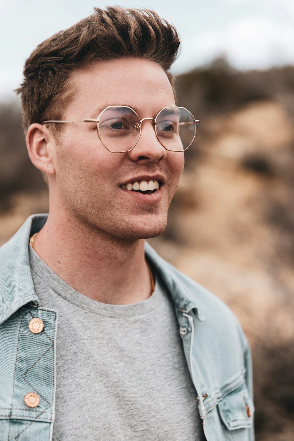 man in blue denim jacket wearing eyeglasses