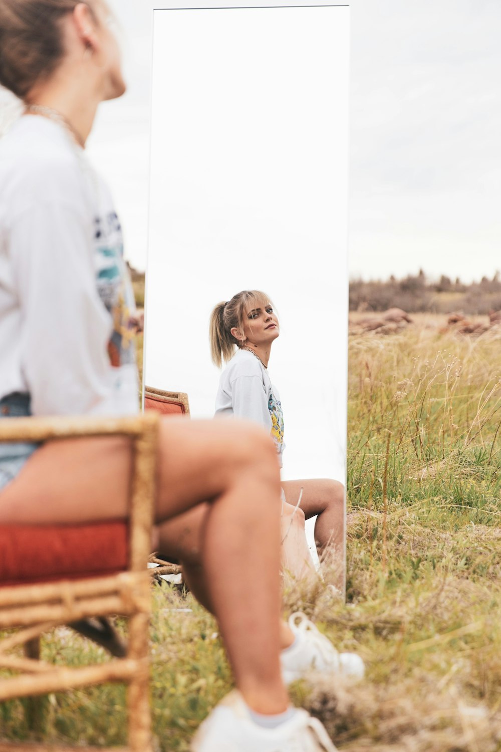 woman in white shirt sitting on brown wooden chair