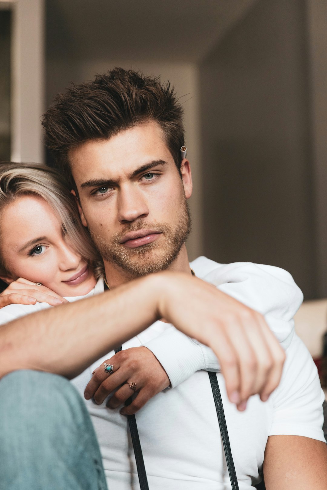 man in white dress shirt hugging woman in blue denim jeans