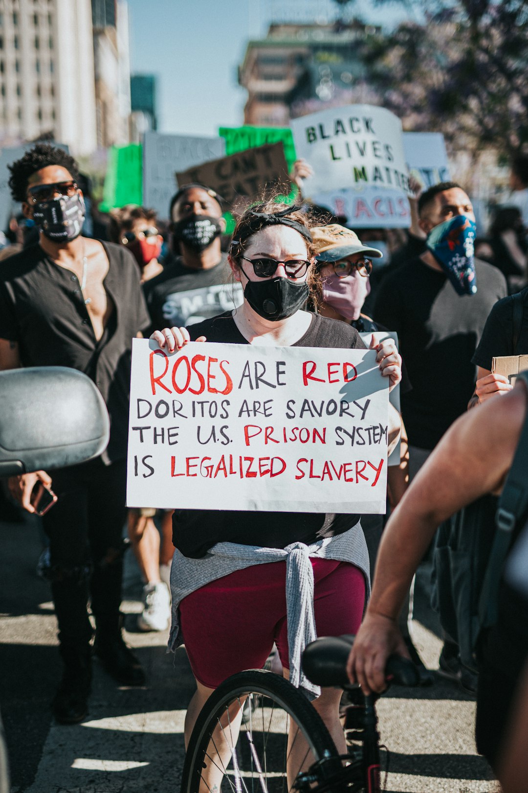 woman in black tank top holding white and red signage