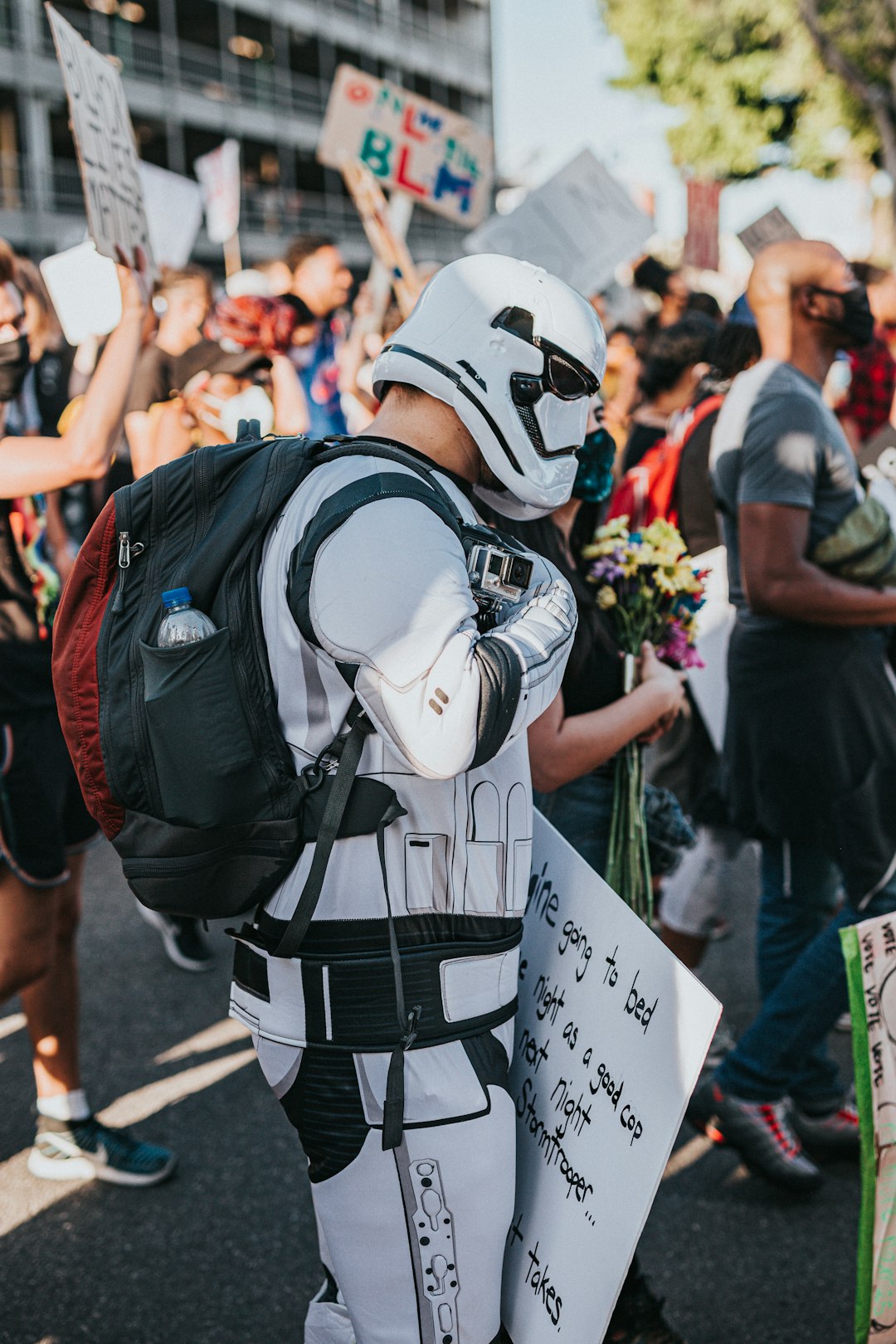 person in white and black mask holding white printer paper