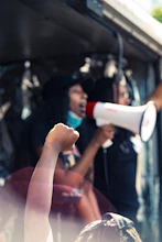a woman holding a megaphone in front of a crowd