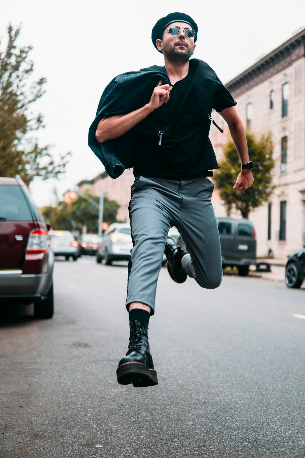man in blue crew neck t-shirt and gray denim jeans jumping on road during daytime