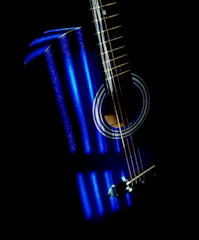 Close-up of a guitar with shadowy blue tones under soft light.