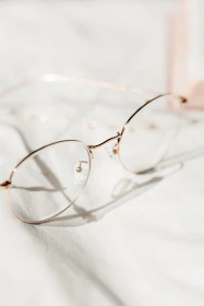 Close-up of elegant eyeglass frames displayed on a soft fabric background.
