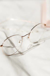 A close-up of stylish eyeglasses resting gently on a soft cloth for delicate cleaning.