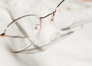 silver framed eyeglasses on white textile