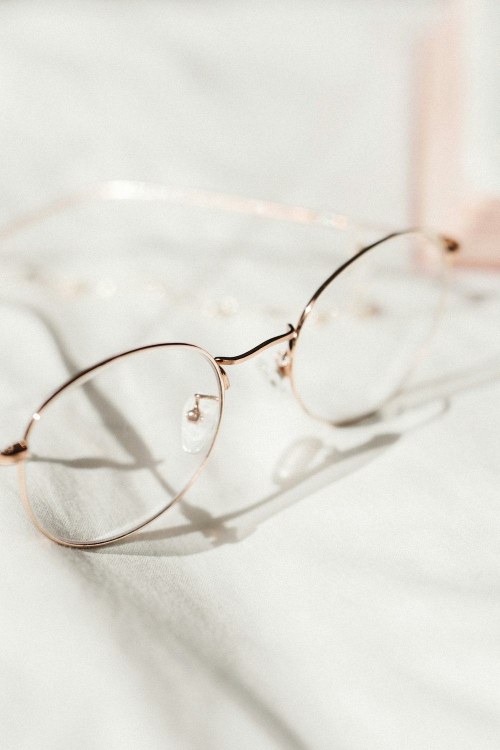 silver framed eyeglasses on white textile