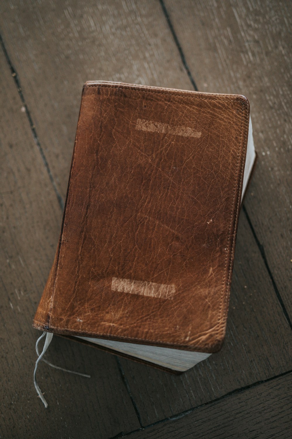 brown leather bifold wallet on brown wooden table