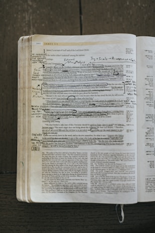 An open book with highlighted verses and annotations in the margins.