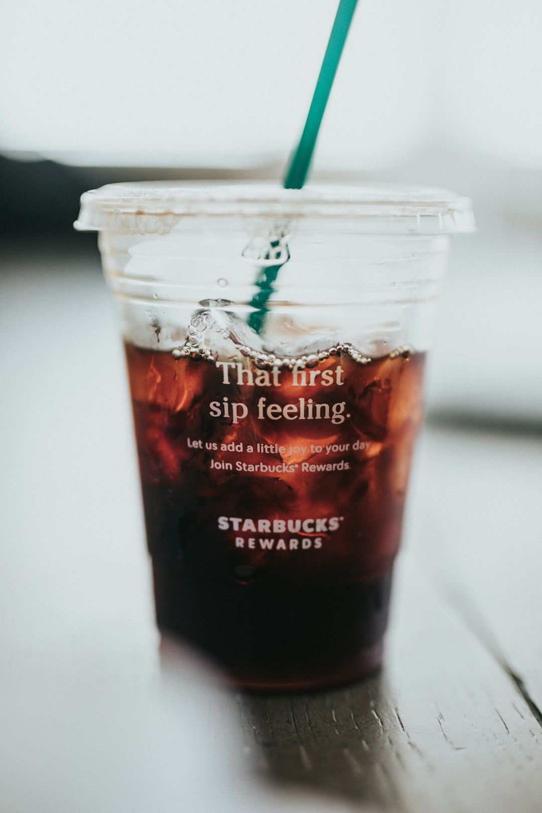 clear plastic cup with red liquid and green straw