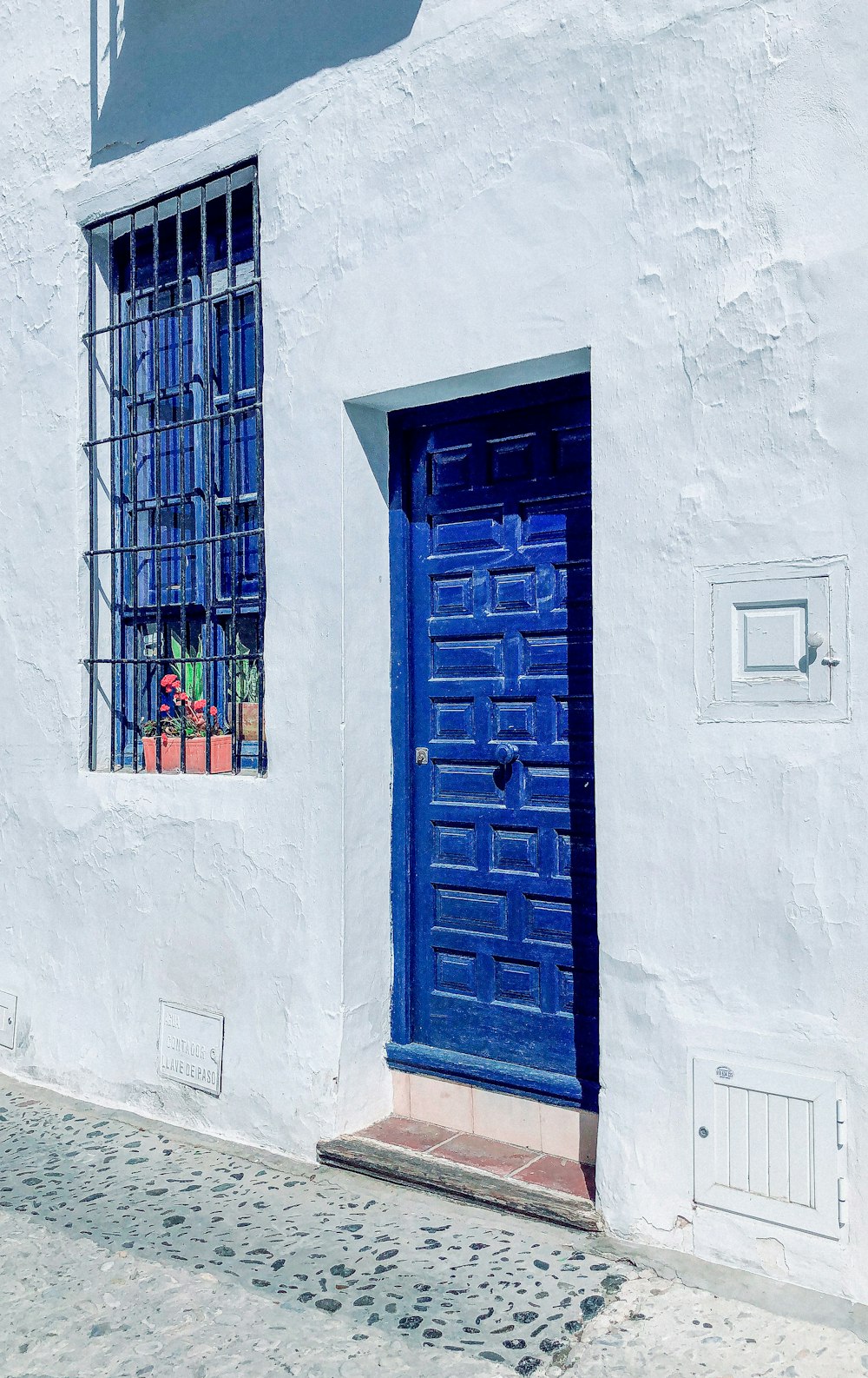 Fenêtre en bois bleu sur mur en béton blanc