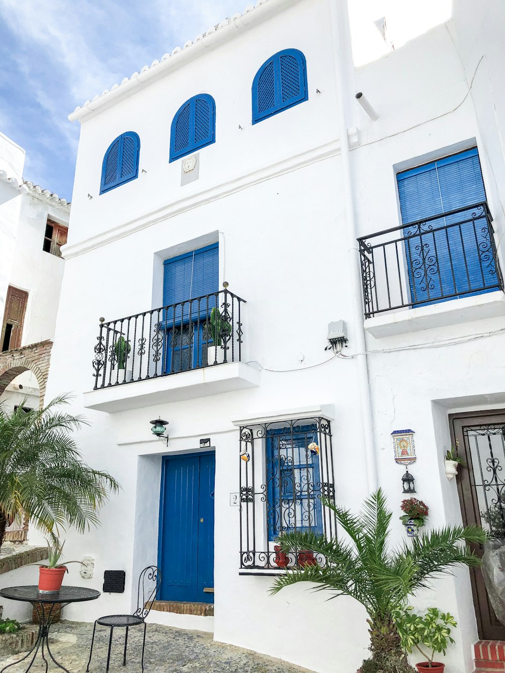 blue wooden door on white concrete building during daytime