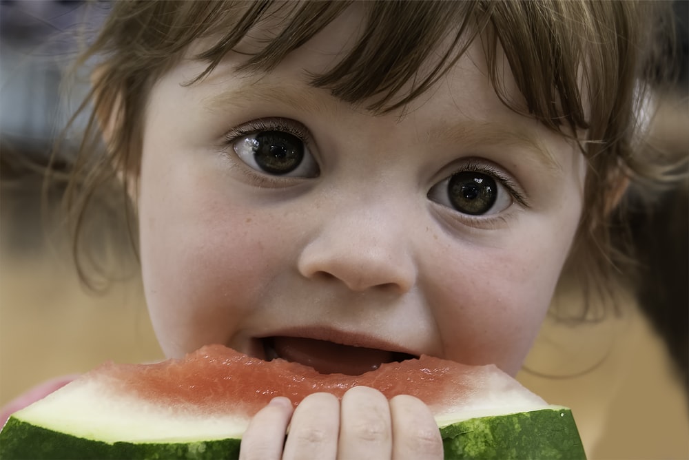 child eating watermelon during daytime
