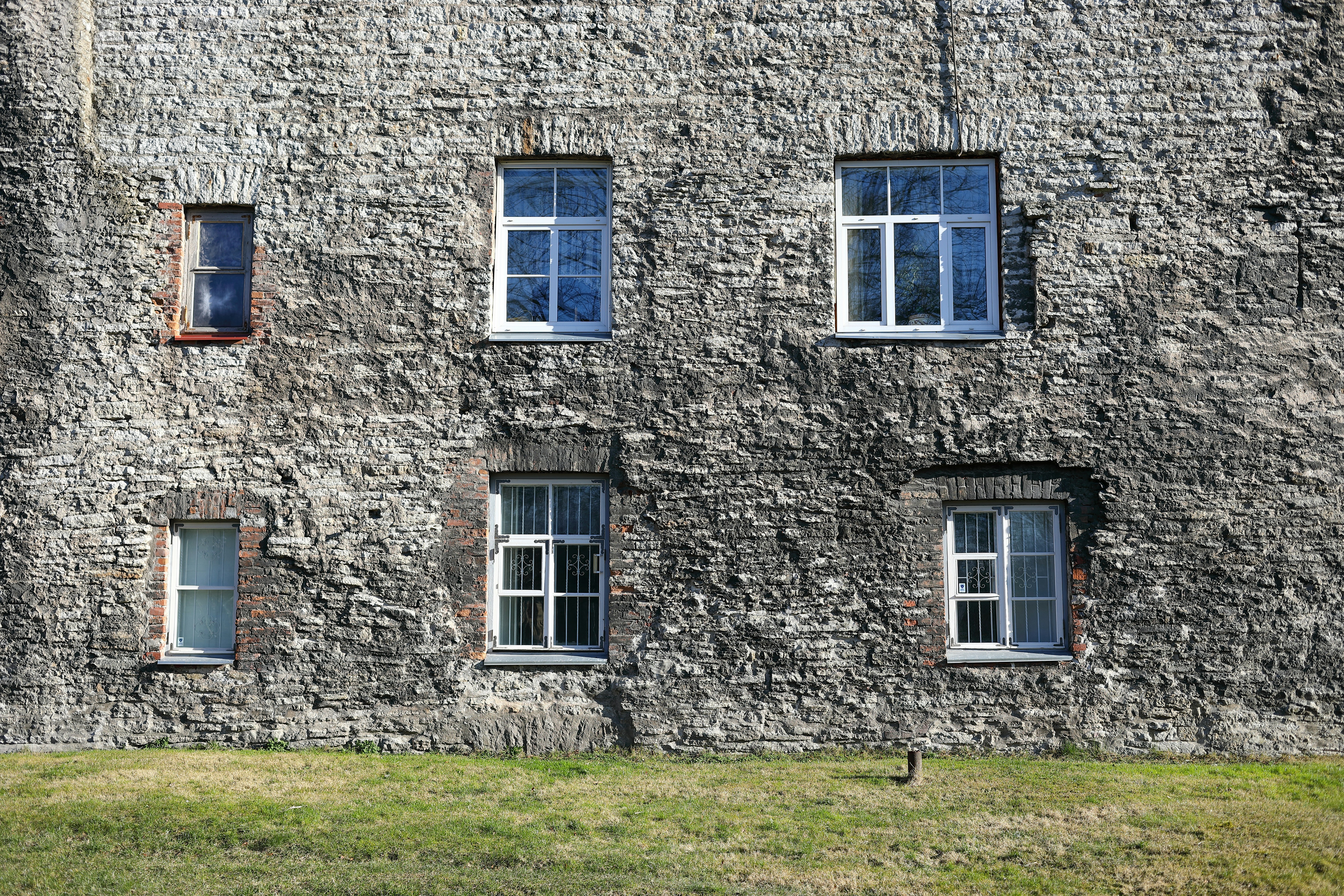 brown brick building with white wooden window estonia teams background