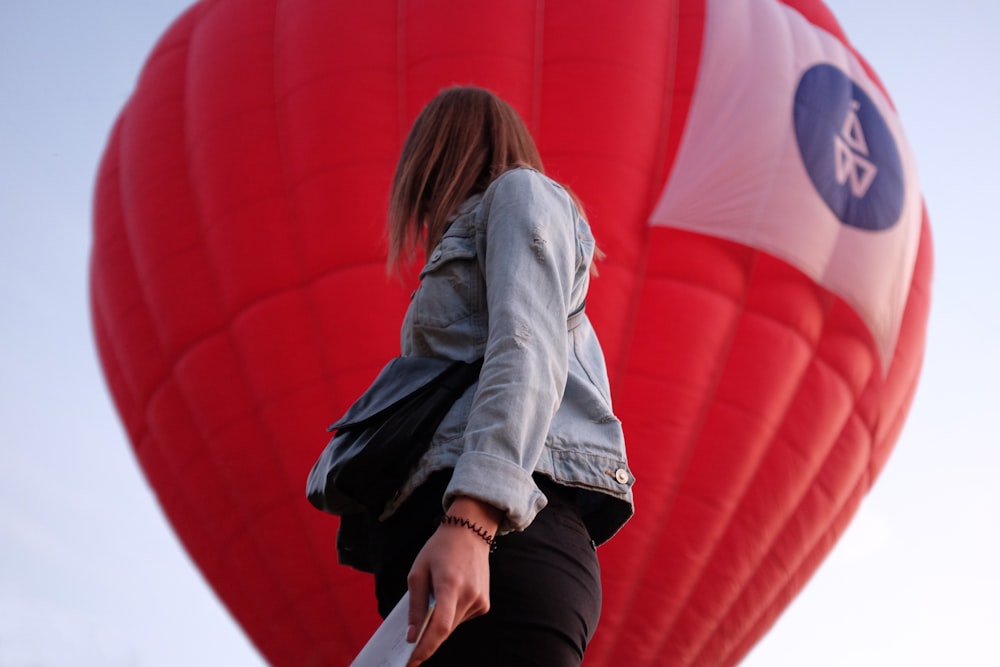 woman in gray hoodie and black pants sitting on red hot air balloon