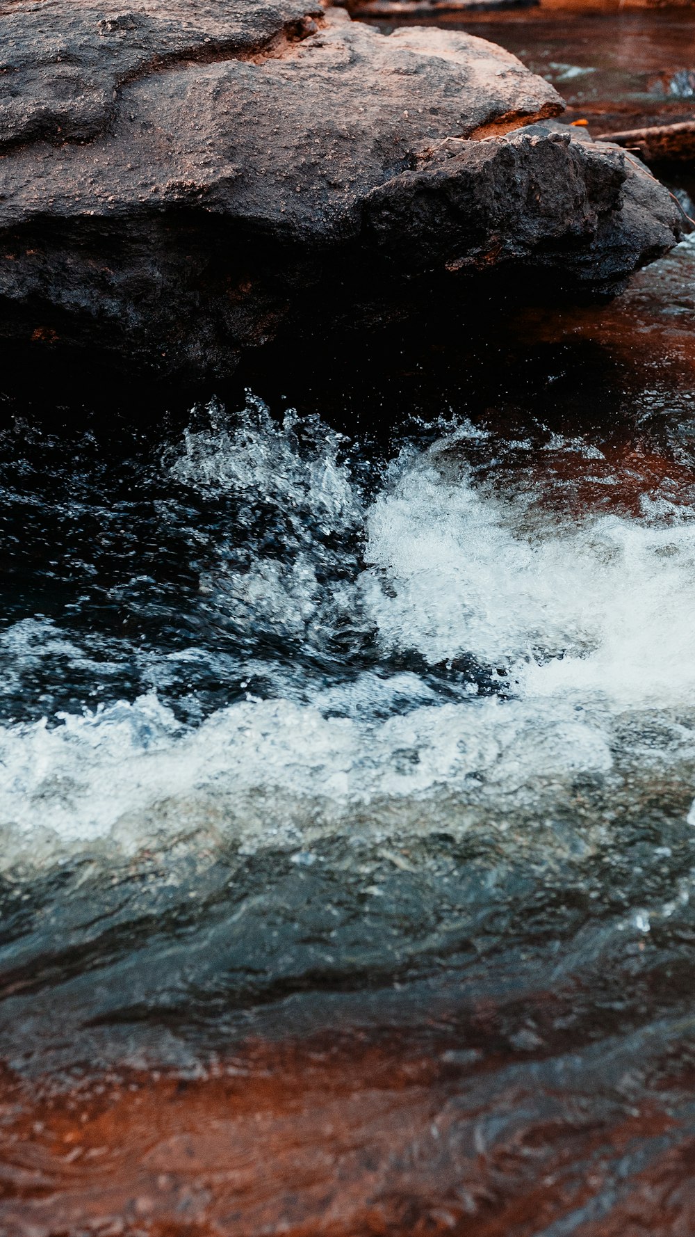 water waves hitting rocks during daytime