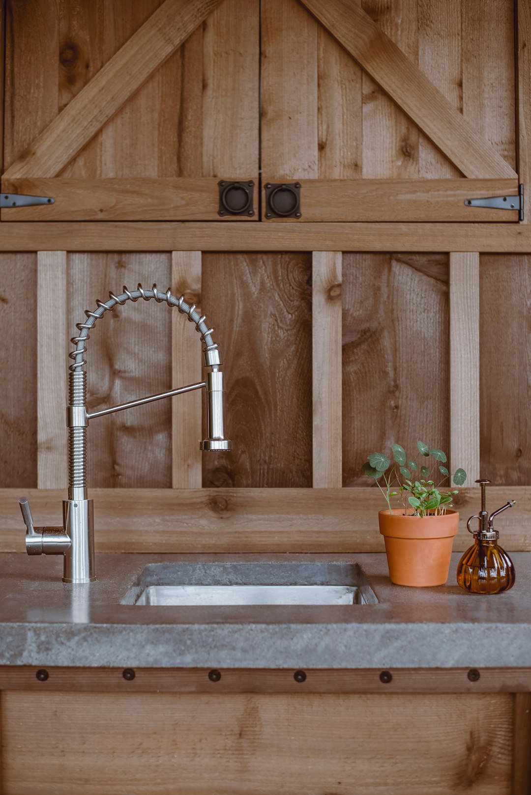 silver faucet on brown wooden cabinet