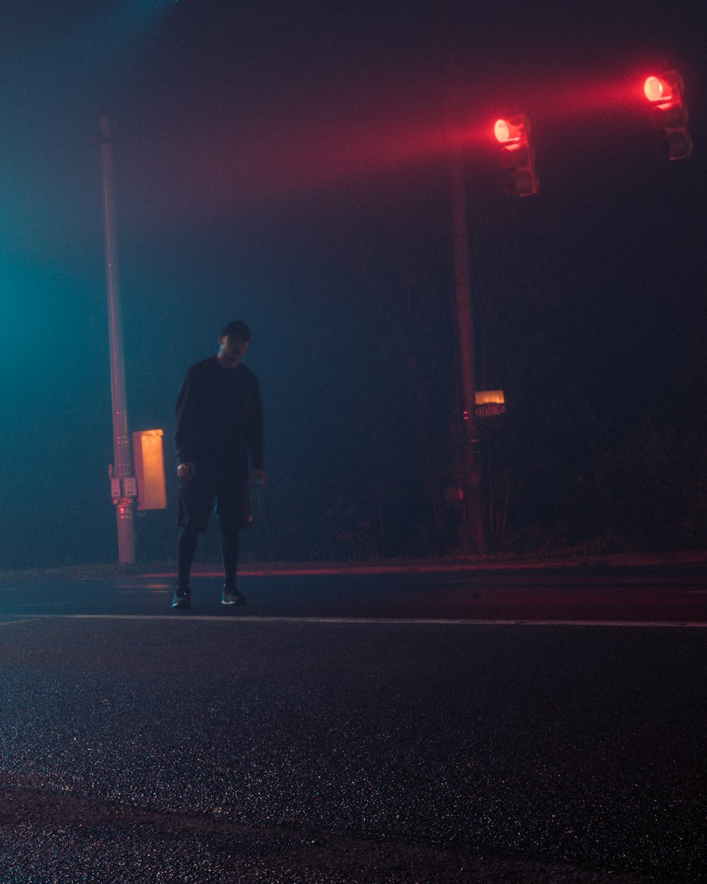 man in black jacket walking on street during night time